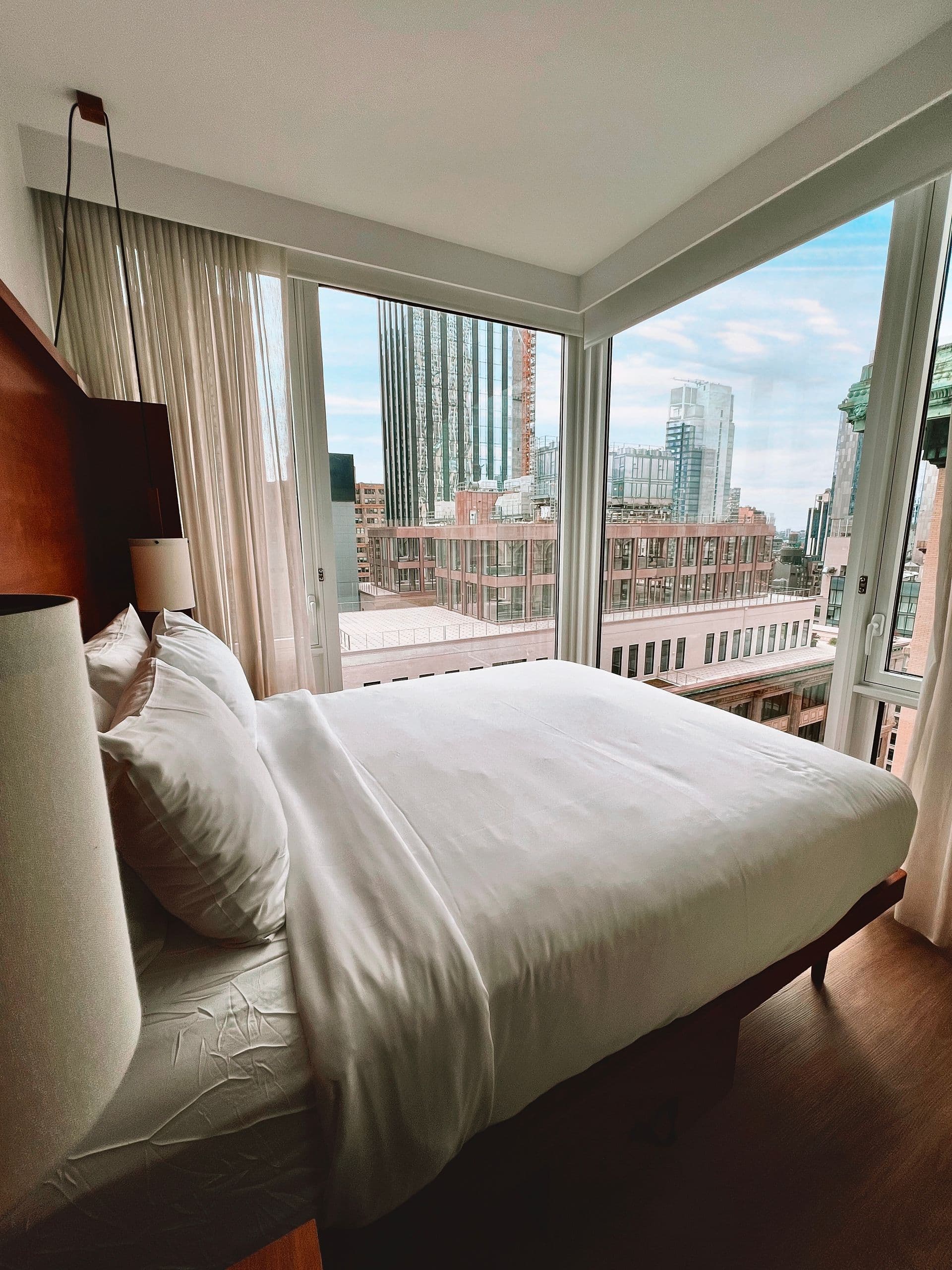 Compact double bedroom beside a corner window