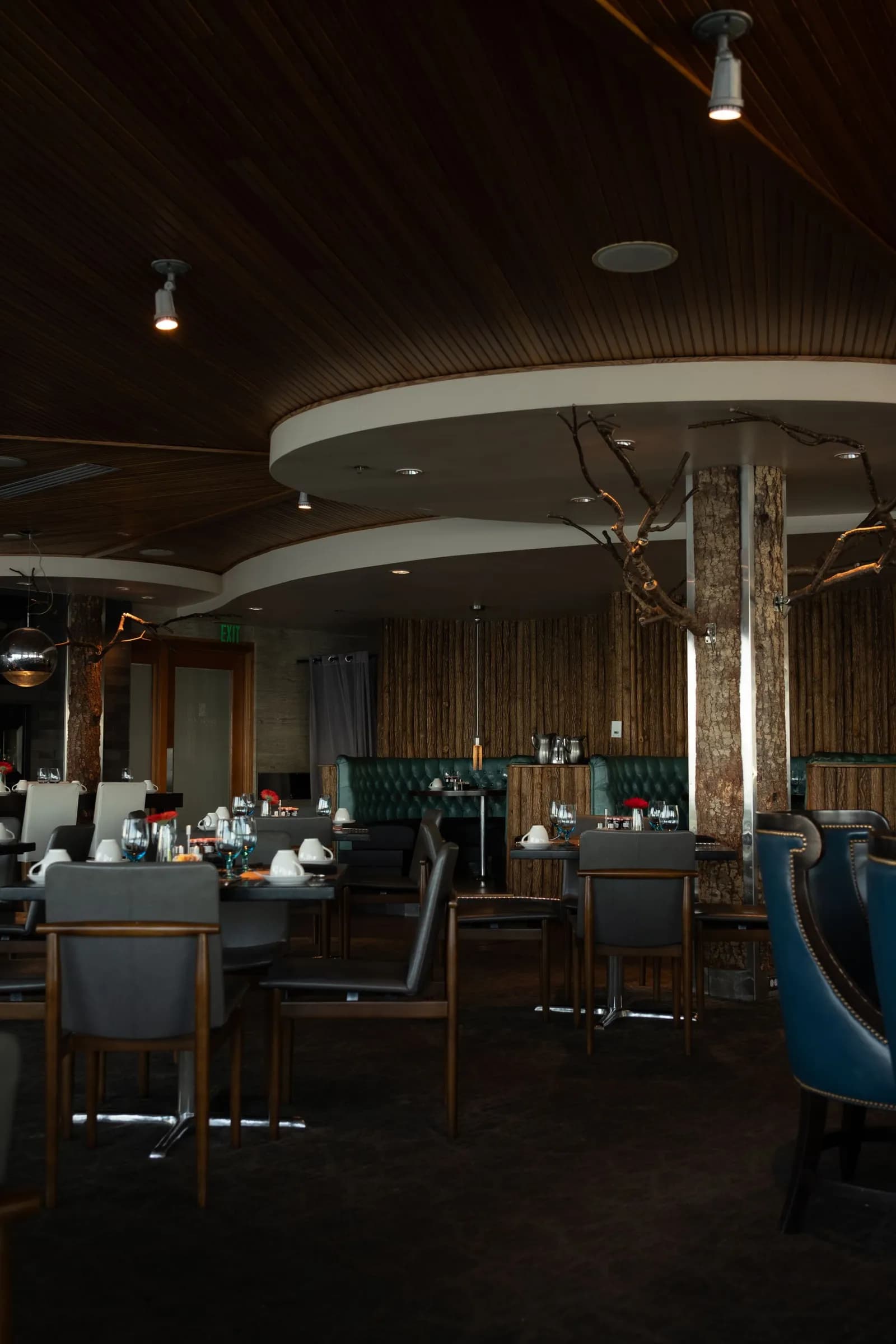 Restaurant dining room with a timber ceiling and blue armchairs