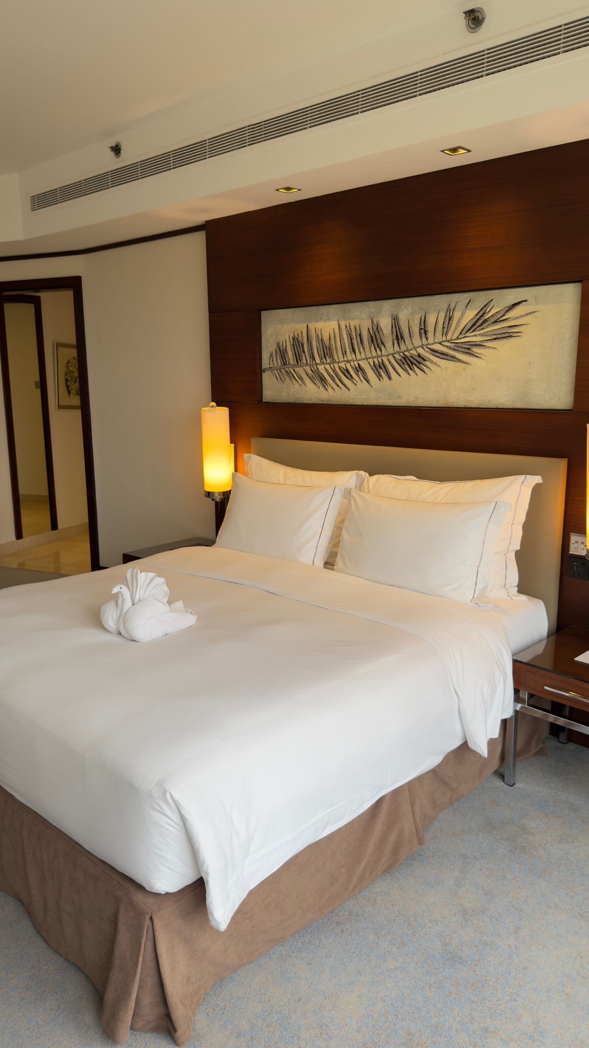 Double bedroom with a timber wall and a fern artwork