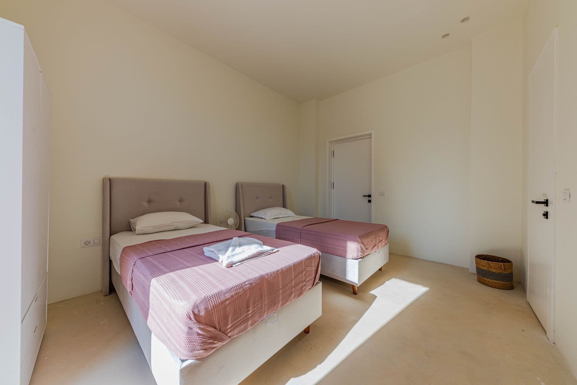 Spacious twin room with two single beds and white walls