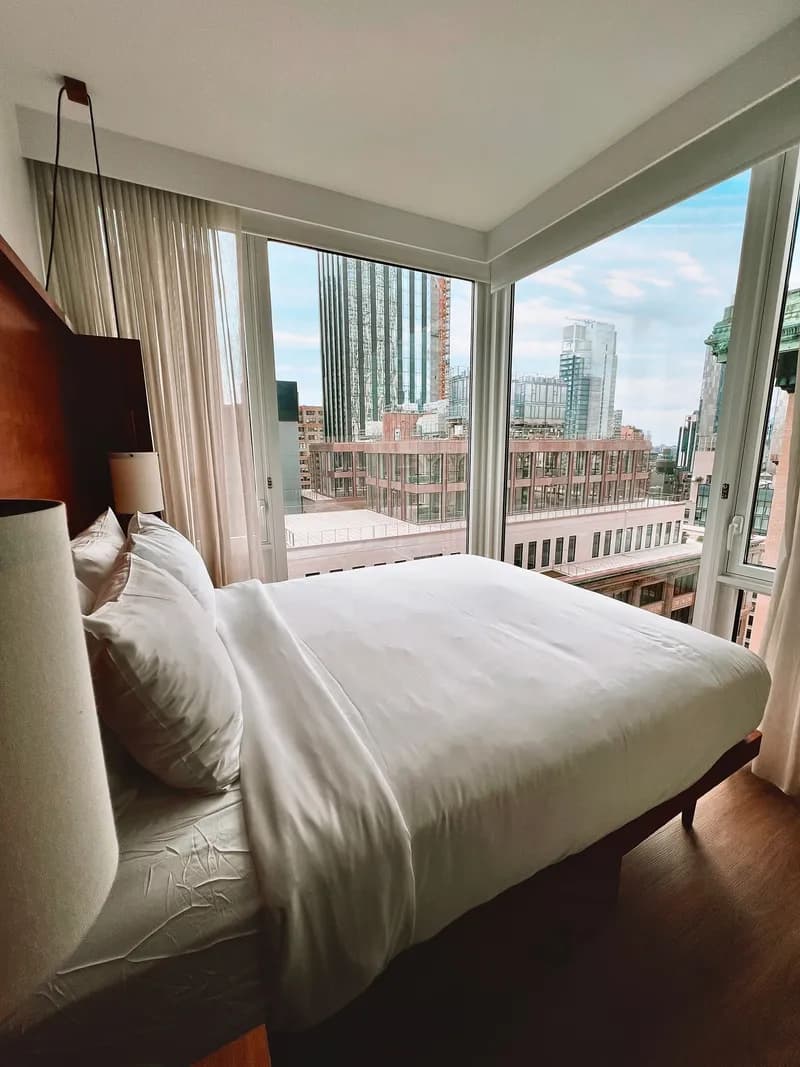 Compact double bedroom beside a corner window