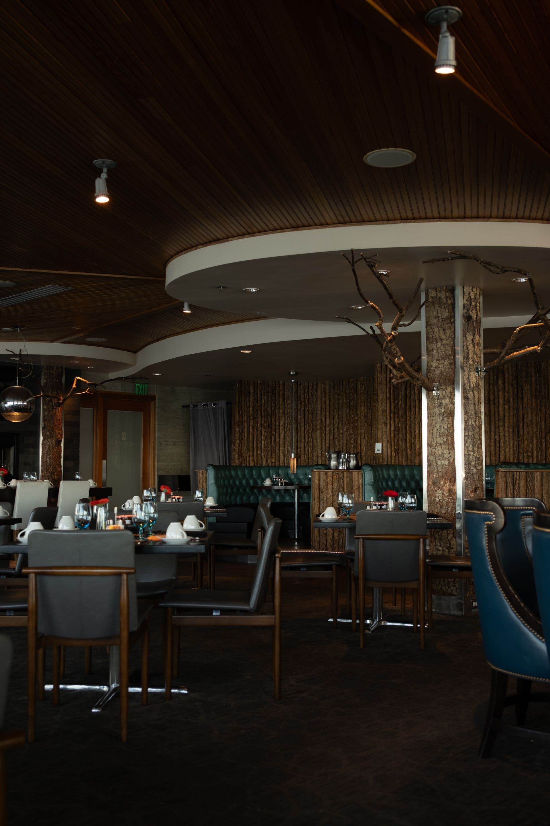 Restaurant dining room with a timber ceiling and blue armchairs