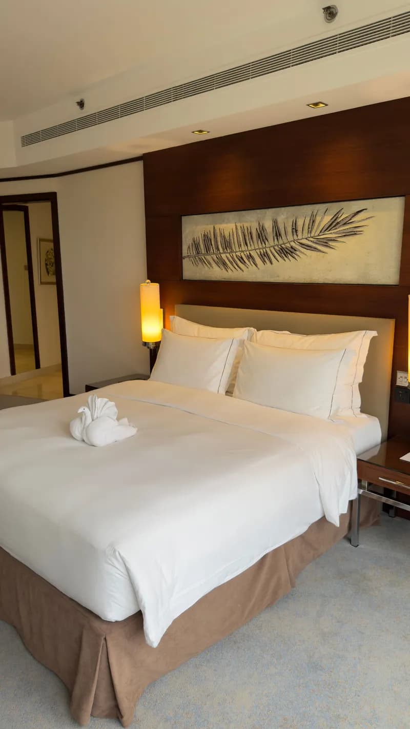 Double bedroom with a timber wall and a fern artwork